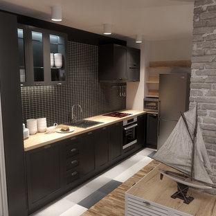 Inspiration for a mid-sized industrial l-shaped open plan kitchen in London with a drop-in sink, beaded inset cabinets, black cabinets, wood benchtops, black splashback, ceramic splashback, stainless steel appliances, terra-cotta floors and no island.