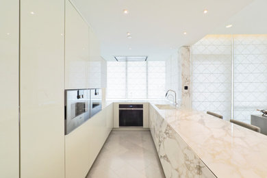 Inspiration for a mid-sized contemporary u-shaped porcelain tile, gray floor and coffered ceiling eat-in kitchen remodel in Vancouver with an integrated sink, flat-panel cabinets, white cabinets, marble countertops, white backsplash, ceramic backsplash, paneled appliances, an island and white countertops