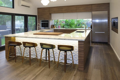 Photo of a large contemporary single-wall kitchen/diner in Hawaii with a submerged sink, flat-panel cabinets, dark wood cabinets, engineered stone countertops, stainless steel appliances, vinyl flooring, an island, brown floors and white worktops.