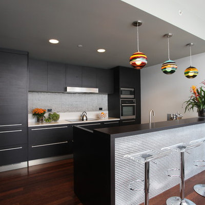 Trendy galley kitchen photo in Los Angeles with flat-panel cabinets, black cabinets, metallic backsplash, paneled appliances and metal backsplash