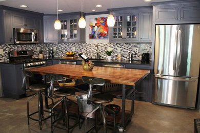 アトランタにあるコンテンポラリースタイルのおしゃれなアイランドキッチン (グレーのキッチンパネル、シルバーの調理設備、コンクリートの床) の写真