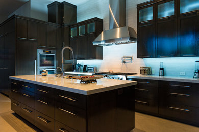 Geräumige Moderne Wohnküche mit Schrankfronten im Shaker-Stil, dunklen Holzschränken, Granit-Arbeitsplatte, Küchenrückwand in Weiß, Küchengeräten aus Edelstahl, zwei Kücheninseln und Unterbauwaschbecken in Miami
