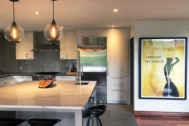 他の地域にある高級な広いコンテンポラリースタイルのおしゃれなキッチン (フラットパネル扉のキャビネット、グレーの床) の写真