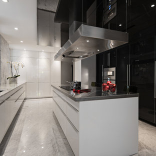 Foto di una cucina design con lavello sottopiano, ante lisce, ante bianche, top in marmo, paraspruzzi bianco, paraspruzzi in lastra di pietra e elettrodomestici in acciaio inossidabile