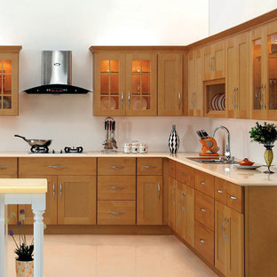 Mid-sized contemporary l-shaped kitchen in Orange County with shaker cabinets, light wood cabinets, a drop-in sink, solid surface benchtops, with island and vinyl floors.