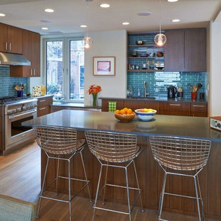 Trendy eat-in kitchen photo in Kansas City with flat-panel cabinets, stainless steel appliances, dark wood cabinets, blue backsplash and subway tile backsplash