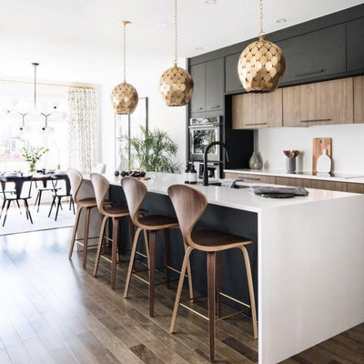 Large trendy single-wall medium tone wood floor and brown floor open concept kitchen photo in Columbus with an undermount sink, flat-panel cabinets, black cabinets, quartzite countertops, white backsplash, stone slab backsplash, stainless steel appliances, an island and white countertops