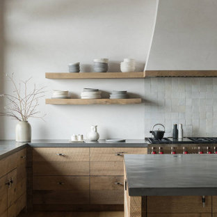 Example of a large trendy l-shaped light wood floor and brown floor open concept kitchen design in Columbus with an undermount sink, flat-panel cabinets, light wood cabinets, quartzite countertops, stainless steel appliances, an island and gray countertops
