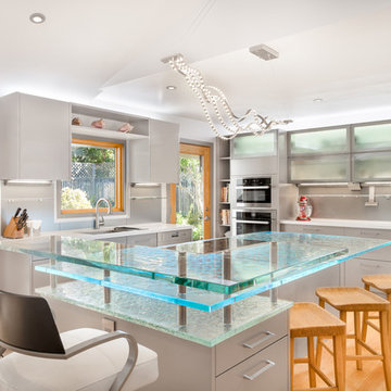 Contemporary kitchen island in California with a raised bar and cast glass count