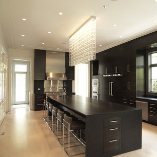 Contemporary kitchen pictures - Example of a trendy kitchen design in Atlanta with paneled appliances, flat-panel cabinets, black cabinets and granite countertops