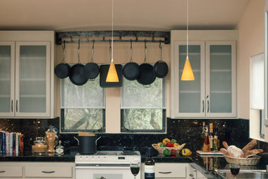 Imagen de cocina actual con armarios tipo vitrina, puertas de armario beige, salpicadero negro y electrodomésticos blancos