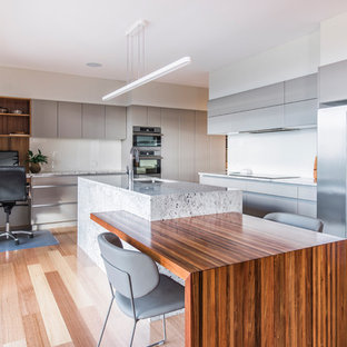 Design ideas for a contemporary l-shaped eat-in kitchen in Hobart with an undermount sink, flat-panel cabinets, grey cabinets, white splashback, glass sheet splashback, stainless steel appliances, light hardwood floors, with island, brown floor and grey benchtop.