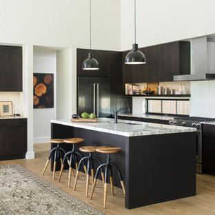 Idee per una cucina parallela minimal con lavello sottopiano, ante lisce, ante in legno bruno, elettrodomestici in acciaio inossidabile, pavimento in legno massello medio, isola e pavimento marrone