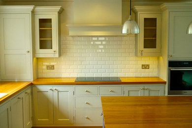 Contemporary l-shaped kitchen in Dorset with wood worktops.