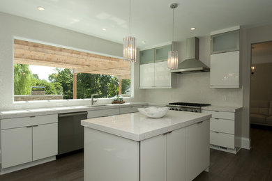 Photo of a contemporary l-shaped kitchen in DC Metro with a single-bowl sink, flat-panel cabinets, white cabinets, quartz worktops, white splashback, mosaic tiled splashback, stainless steel appliances and an island.