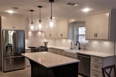 Inspiration for a large contemporary l-shaped eat-in kitchen remodel in Dallas with a farmhouse sink, shaker cabinets, white cabinets, quartzite countertops, white backsplash, subway tile backsplash, stainless steel appliances, an island and white countertops