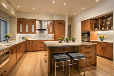 Example of a mid-sized trendy u-shaped medium tone wood floor eat-in kitchen design in Phoenix with an undermount sink, flat-panel cabinets, medium tone wood cabinets, white backsplash, stainless steel appliances, an island and quartzite countertops