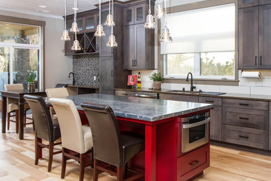 Mid-sized trendy l-shaped light wood floor open concept kitchen photo in Other with a drop-in sink, ceramic backsplash, stainless steel appliances, an island, shaker cabinets, dark wood cabinets, stainless steel countertops and white backsplash
