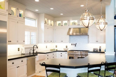 Eat-in kitchen - contemporary l-shaped medium tone wood floor and gray floor eat-in kitchen idea in Salt Lake City with a farmhouse sink, shaker cabinets, white cabinets, quartz countertops, white backsplash, stainless steel appliances and an island