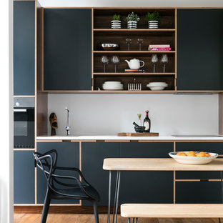 Ispirazione per una cucina abitabile minimal con ante lisce, ante nere e pavimento in legno massello medio
