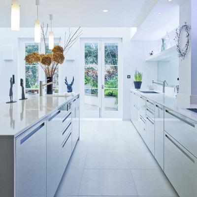Example of a trendy galley kitchen design in London with flat-panel cabinets and gray cabinets