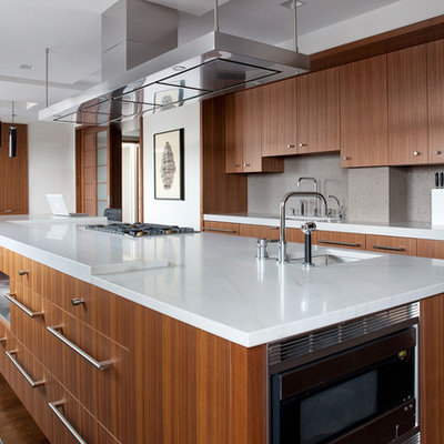Trendy galley eat-in kitchen photo in Boston with an undermount sink, flat-panel cabinets, medium tone wood cabinets, gray backsplash, stainless steel appliances and an island