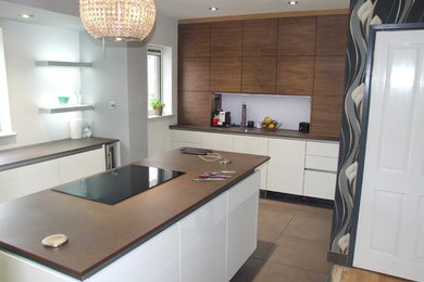 Photo of a medium sized contemporary l-shaped kitchen/diner in Other with a submerged sink, flat-panel cabinets, white cabinets, composite countertops, glass sheet splashback, stainless steel appliances, porcelain flooring and an island.