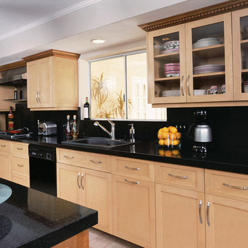 Contemporary kitchen with black glass counter and light cabinets