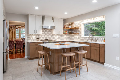 This is an example of a medium sized modern l-shaped kitchen/diner in Baltimore with a submerged sink, flat-panel cabinets, white cabinets, engineered stone countertops, white splashback, ceramic splashback, stainless steel appliances, ceramic flooring, an island, grey floors and white worktops.