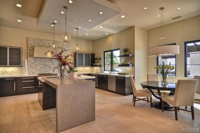 Photo of a medium sized contemporary l-shaped kitchen/diner in Orange County with a submerged sink, flat-panel cabinets, dark wood cabinets, soapstone worktops, stainless steel appliances, marble flooring, an island and beige floors.