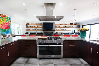 Offene, Mittelgroße Moderne Küche in U-Form mit flächenbündigen Schrankfronten, dunklen Holzschränken, Küchengeräten aus Edelstahl, Kücheninsel und grauem Boden in Los Angeles