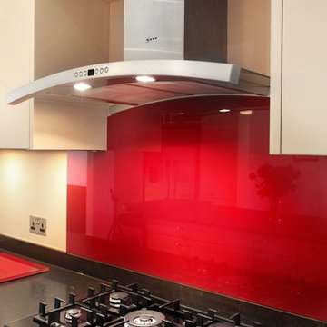 Contemporary kitchen with red glass splash back