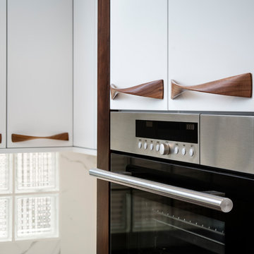 Contemporary Kitchen with White Cabinet Uppers and Walnut Handles