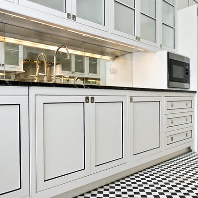 Small trendy galley ceramic tile enclosed kitchen photo in New York with an undermount sink, flat-panel cabinets, white cabinets, granite countertops, mirror backsplash, stainless steel appliances and no island