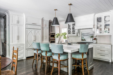 Eat-in kitchen - traditional l-shaped dark wood floor and brown floor eat-in kitchen idea in Atlanta with recessed-panel cabinets, white cabinets, white backsplash, stainless steel appliances, an island and white countertops