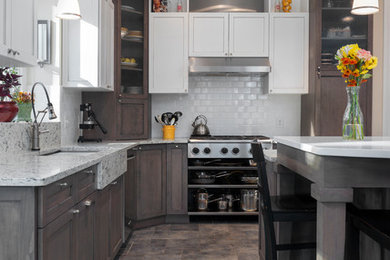Inspiration for a transitional slate floor and gray floor kitchen remodel in Detroit with an undermount sink, flat-panel cabinets, gray cabinets, quartzite countertops, white backsplash, subway tile backsplash, stainless steel appliances and an island