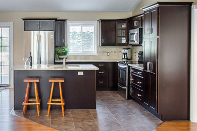Mid-sized transitional l-shaped porcelain tile and brown floor open concept kitchen photo in Toronto with an undermount sink, shaker cabinets, dark wood cabinets, granite countertops, beige backsplash, ceramic backsplash, stainless steel appliances and an island