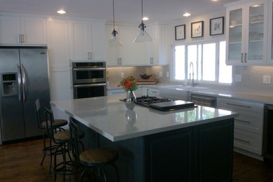 Exempel på ett stort klassiskt kök, med en rustik diskho, skåp i shakerstil, vita skåp, rostfria vitvaror, mörkt trägolv, en köksö och brunt golv