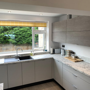 Contemporary light grey and concrete kitchen with marble laminate worktops