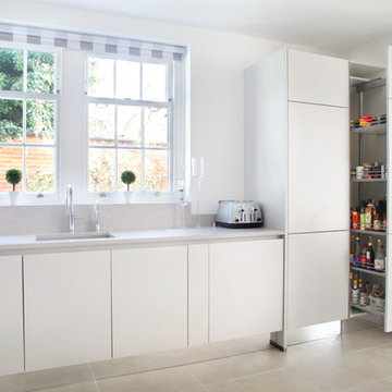 Contemporary light grey handle-less kitchen with a variety of storage options