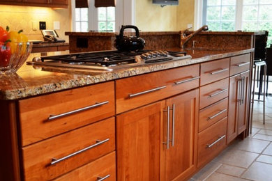Inspiration for a large contemporary l-shaped eat-in kitchen remodel in New York with an undermount sink, shaker cabinets, medium tone wood cabinets, beige backsplash, ceramic backsplash, stainless steel appliances and an island