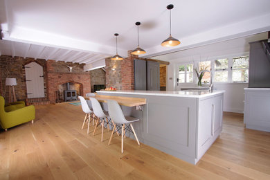 Inspiration for a large contemporary l-shaped open plan kitchen in Surrey with shaker cabinets, grey cabinets, granite worktops, stainless steel appliances, medium hardwood flooring, a breakfast bar and multicoloured worktops.