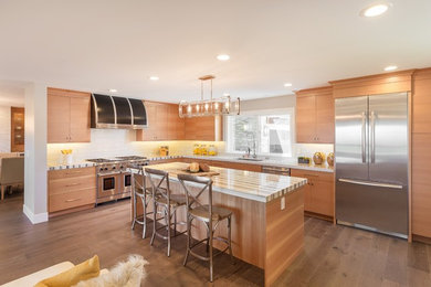 Trendy light wood floor kitchen photo in San Francisco with an undermount sink, flat-panel cabinets, light wood cabinets, white backsplash, stainless steel appliances and an island