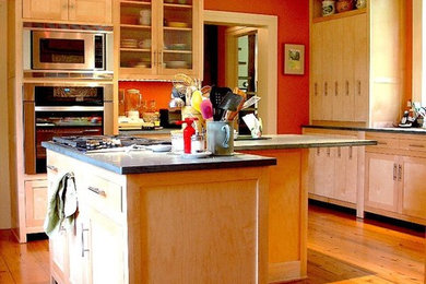 ジャクソンにあるコンテンポラリースタイルのおしゃれなキッチン (シルバーの調理設備、淡色無垢フローリング、落し込みパネル扉のキャビネット、中間色木目調キャビネット、御影石カウンター) の写真