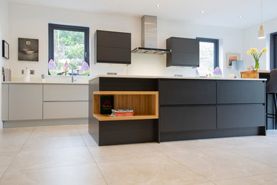Photo of a large contemporary galley kitchen/diner in Other with an integrated sink, flat-panel cabinets, grey cabinets, composite countertops, white splashback, stone slab splashback, black appliances, porcelain flooring, an island, grey floors and white worktops.