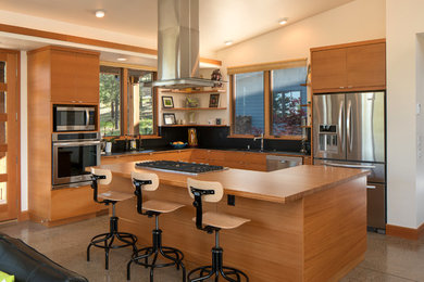 Inspiration for a mid-sized modern l-shaped open concept kitchen remodel in Phoenix with flat-panel cabinets, light wood cabinets, wood countertops, black backsplash, stainless steel appliances and an island
