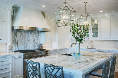 Open concept kitchen - transitional l-shaped dark wood floor and brown floor open concept kitchen idea in Boston with white cabinets, marble countertops, gray backsplash, an undermount sink, shaker cabinets, subway tile backsplash, stainless steel appliances and an island