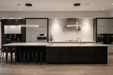 Inspiration for a large contemporary single-wall light wood floor and multicolored floor open concept kitchen remodel in Toronto with an undermount sink, flat-panel cabinets, gray cabinets, quartz countertops, white backsplash, porcelain backsplash, stainless steel appliances, an island and white countertops