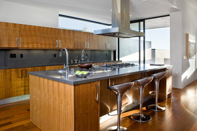 ロサンゼルスにあるコンテンポラリースタイルのおしゃれなキッチン (アンダーカウンターシンク、フラットパネル扉のキャビネット、中間色木目調キャビネット、グレーのキッチンパネル) の写真