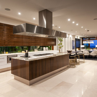 This is an example of an expansive contemporary single-wall eat-in kitchen in Orange County with an undermount sink, flat-panel cabinets, medium wood cabinets, marble benchtops, stainless steel appliances, marble floors, with island, beige floor and beige benchtop.